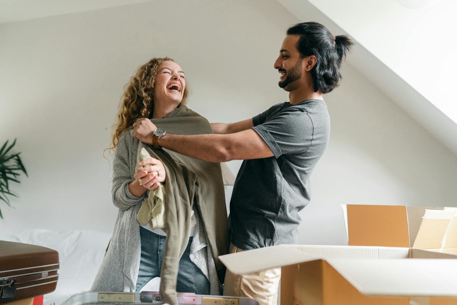 Glückliches Paar packt Umzugskartons in der neuen Wohnung aus